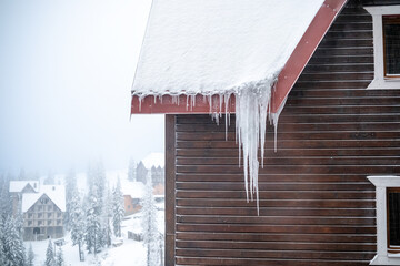 Huge icicles hanging from the roof of a house, close-up