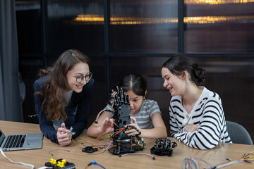 Teacher working with children engineering classroom education stem technology school. Students...