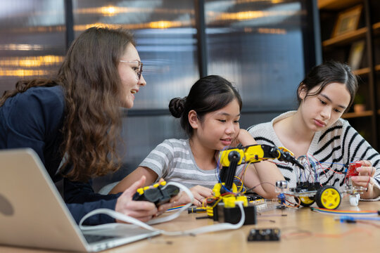 Teacher working with children engineering classroom education stem technology school. Students learning innovation electronic diy robot robot human hand. showcasing creativity and learning.