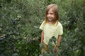 a girl in a yellow T-shirt is looking into a camera