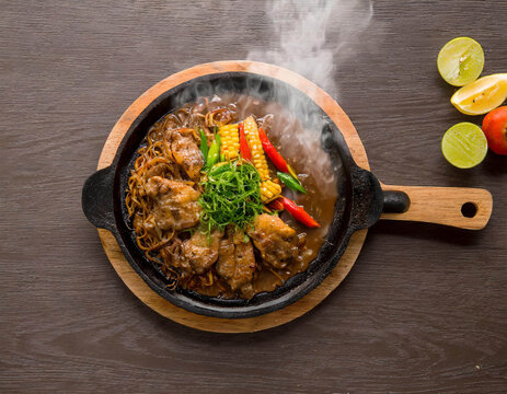 Steaming hot sizzler on wood top view
