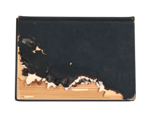 An old, worn-out book with a damaged cover and exposed pages, showcasing signs of age and wear.