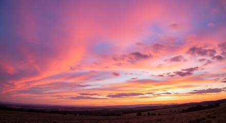 Vibrant Pink and Orange Sunset over Rolling Hills with Scattered Trees