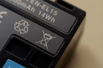 Used Battery with Recycling Symbol and Crossed-Out Trash Can Icon for Safe Disposal Awareness
