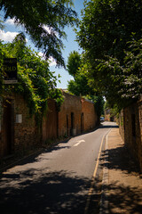 Quiet narrow street with brick walls and greenery in Chiswick, London.