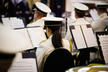 Unrecognizable woman seen from behind playing in a military orchestra
