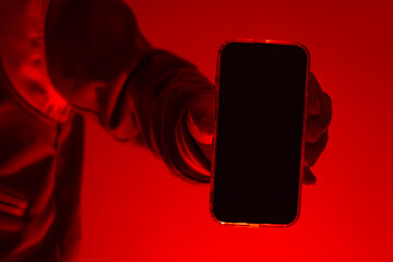 Modern smartphone in a man's hand with a close-up mockup of the screen. The man holds the device...