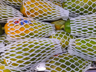 Papaya for sale at the market with fruit protective net.