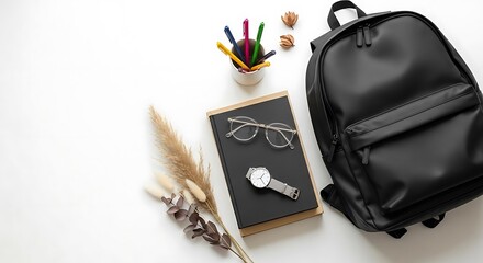 Flat lay of a black backpack with books glasses watch and pens on a white surface arrangement