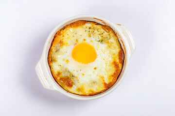 a baked egg in a white dish on a white surface