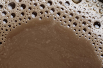 Macro of hot coffee drink texture, coffee foam with bubbles in the background. Top view, coffee cream texture with fragrant coffee background, bubble banner design.