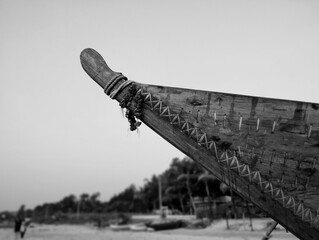 A traditional fisherman’s boat in black and white. The boat points towards the vast expanse of...
