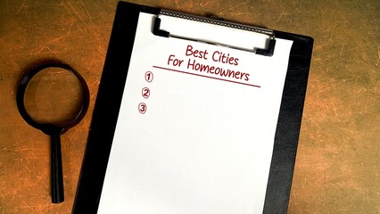 concept of writing Best Cities For Homeowners on a notebook isolated on a wooden table. magnifying glass as decoration.
