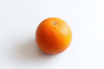 an orange on a white surface with a green stem