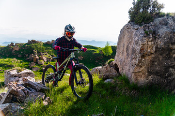 Mountain biker on a rocky trail. A male cyclist pushes his bike up a cliff, climbs up on foot....