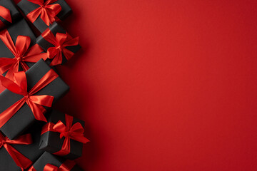 Stylish black gift boxes adorned with red satin ribbons, perfect for celebrations, shopping,...