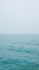 Obraz premium Calm Turquoise Ocean Water Under a Hazy Sky nature
