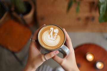 Hands Holding Latte Art Coffee Cup with Swan Design in a Cosy Caf Atmosphere Perfect Morning Treat