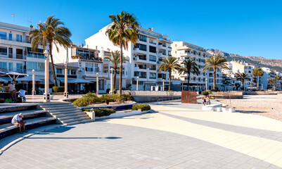 Altea, coastal town with promenade, apartments, palm trees and calm atmosphere on a sunny day