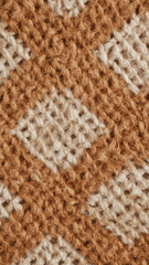 Close up of knitted fabric with diamond pattern in brown and cream yarn texture wool
