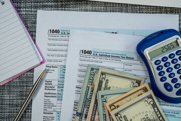 Financial documents and dollar bills for U.S. tax season preparation with 1040 forms
