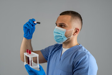 Scientist man doctor wear uniform mask and gloves holding sample blood test tube isolated