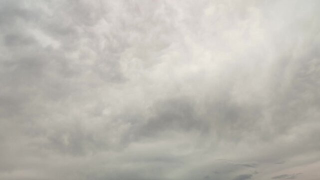 Timelapse of an overcast sky background covered with moving gray cloud texture