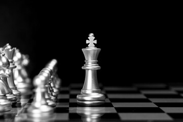 Silver chess king leading pawns. Business leadership, teamwork, and guidance strategy concept....