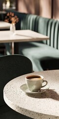 Fototapeta premium A coffee cup sits on a round, speckled table in a modern cafe