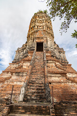 Ancient brick staircase rising to the central prang at Wat Chaiwatthanaram in Ayutthaya, Thailand under a cloudy sky