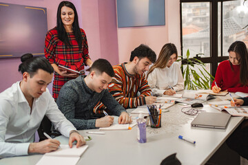 Female teacher with teenage students at language school