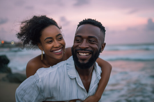 Happy young couple enjoying a romantic piggyback ride on the beach during a beautiful sunset
