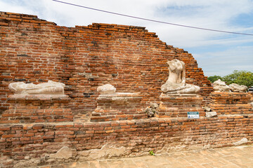 Fragmented and headless Buddha sculptures on pedestals at Wat Chaiwatthanaram in Ayutthaya, Thailand