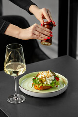 Chef adding pepper to gourmet bruschetta with white wine pairing