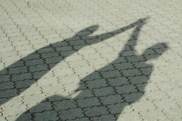 Shadows of People Holding Hands with Raised Arms
