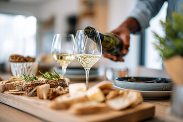 Young host placing drinks and snacks on table before a home gathering, cozy interior, 