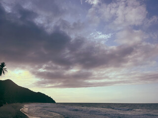 Beautiful panoramic view of the sunset in Cuyagua, Venezuela, beach waves and foam under a sky full of clouds and color