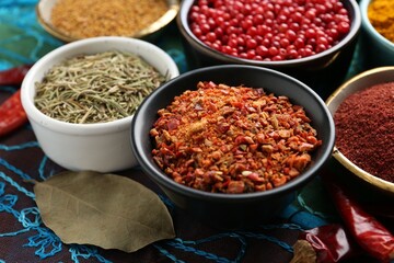 Different aromatic spices on blue tablecloth, closeup