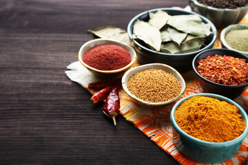 Different aromatic spices on wooden table, closeup. Space for text