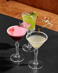 Bartender preparing colorful cocktails on bar counter