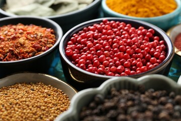 Different aromatic spices on blue tablecloth, closeup