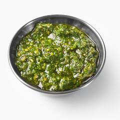 Fresh pesto sauce with olive oil in a small bowl on white background