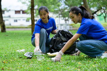 Volunteers collecting garbage in park wearing gloves and blue shirts