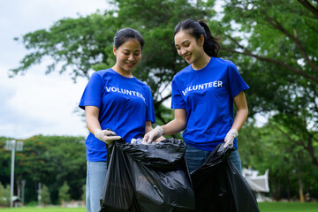 Young volunteers collecting garbage in park wearing blue shirts © PaeGAG