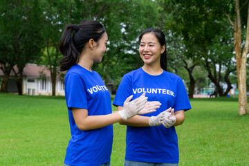 Volunteers wearing gloves and blue t-shirts talking in a park
