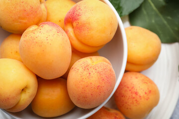 Fresh apricots in bowl on table, top view
