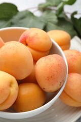 Fresh apricots in bowl on table, closeup