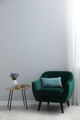 Comfortable armchair and decor near light gray wall indoors