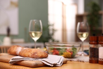 Tasty food and white wine on wooden table indoors, closeup