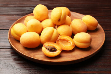 Many fresh apricots on wooden table, closeup
